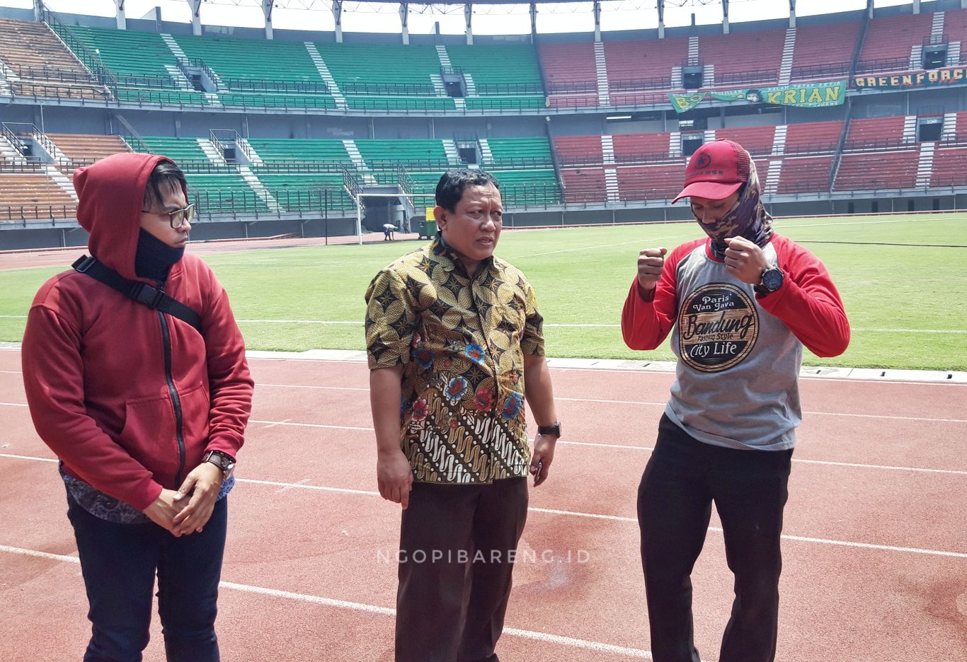 Kadispora Surabaya, Afghani Wardhana saat koordinasi dengan pekerja stadion GBT. (Foto: Haris/ngopibareng.id)