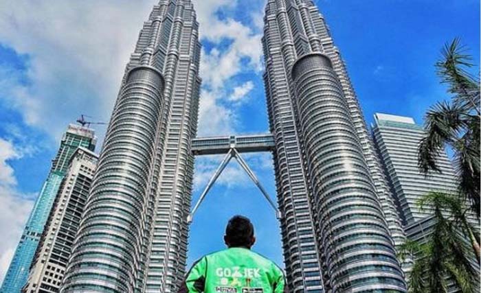 Ilustrasi GoJek di bawah Menara Petronas, Kuala Lumpur, Malaysia. (Foto:Hipwee)