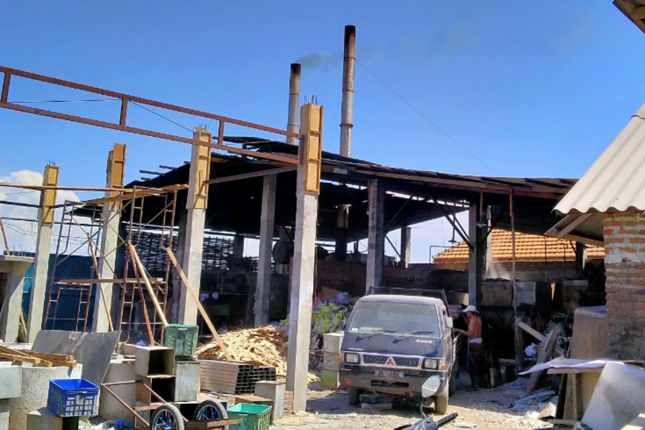 Asap hitam keluar dari salah satu rumah produksi industri tahu di Desa Tropodo, Krian, Sidoarjo, Senin 18 November 2019. (Foto: Fariz/ngopibareng.id)