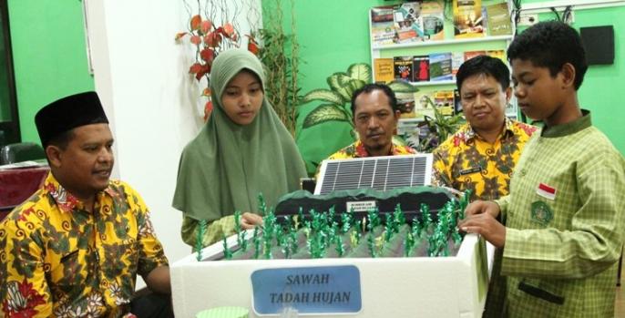 Dua siswa MTsN 1 Pasuruan didampingi guru dan kepala sekolah menunjukkan hasil karya robot penyiram tanaman. (Foto: Dok Humas)