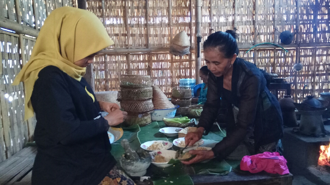 Salah satu mahasiswi bersama juru masak makanan ritual adat di Cungking sedang membuat Tumpeng Serakat