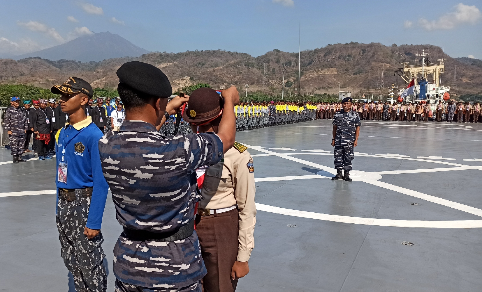 Komandan Lanal Banyuwangi Letkol Laut (P) Yulius Azz Zaenal menyematkan tanda peserta Latihan Bela Negara di atas KRI Surabaya 591. (Foto: Muh Hujaini/ngopibareng.id)