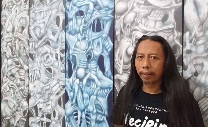 Wahyu Nugoro di depan karyanya pada pameran tunggal  Intuitive Drawing di Bocosralus Artspace, Pasuruan. (Foto: ngopibareng/m. anis)