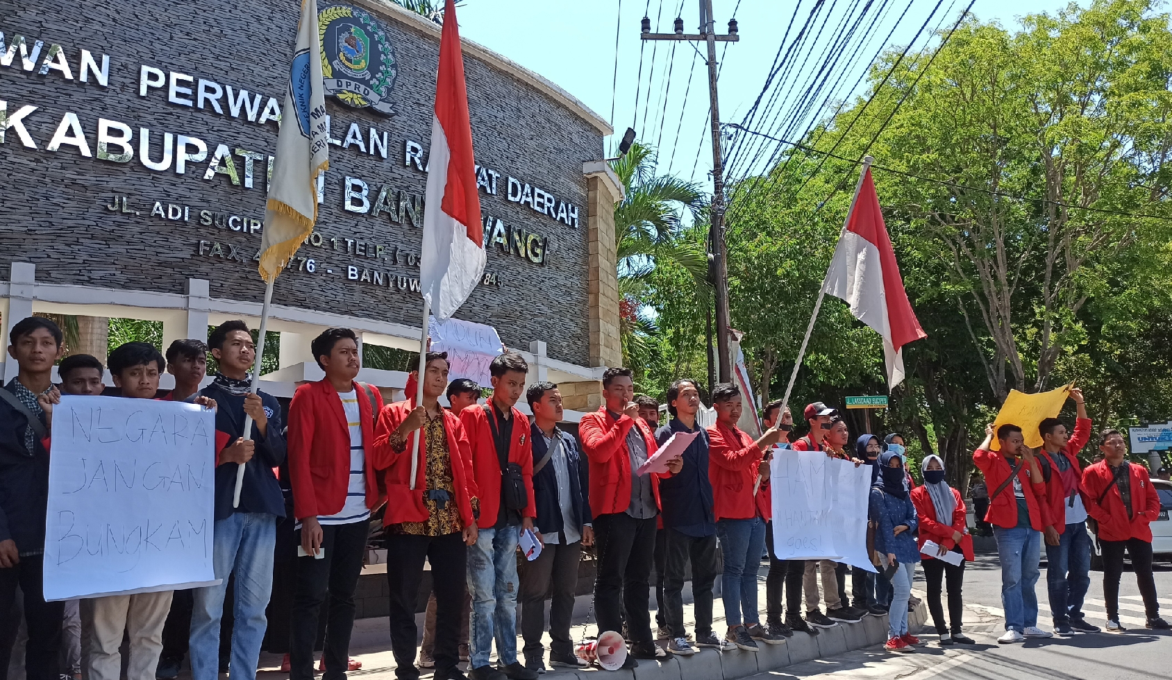 Puluhan mahasiswa melakukan aksi untuk memperingati Hari HAM Sedunia di simpang tiga Gedung DPRD Banyuwangi. (Foto: Hujaini/Ngopibareng.id)