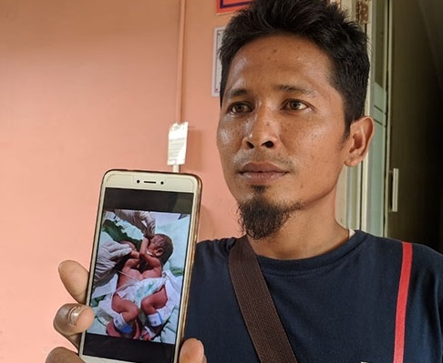 Supono, 33 tahun, memperlihatkan foto bayi kembar siam dempet dada dan perut, Rabu 11 Desember 2019. (Foto: Analisis.com)