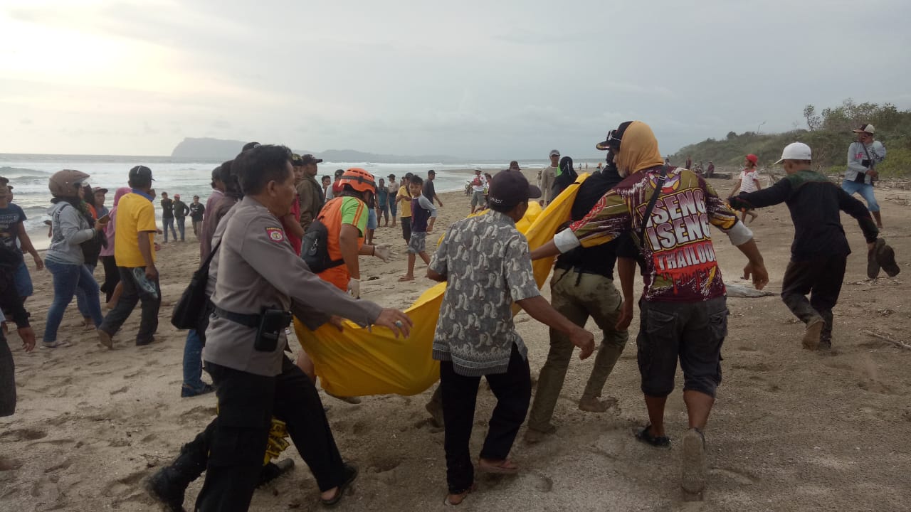 Petugas bersama warga mengevakuasi jenazah Sulton dari Pantai Trianggulasi.