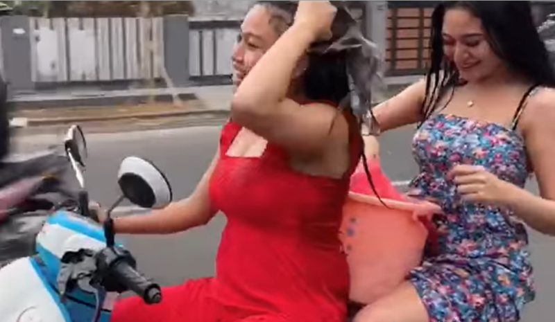 Tangkapan layar dua perempuan mandi di atas motor sambil berjalan di jalan raya. (Foto: Tangkapan Layar)   