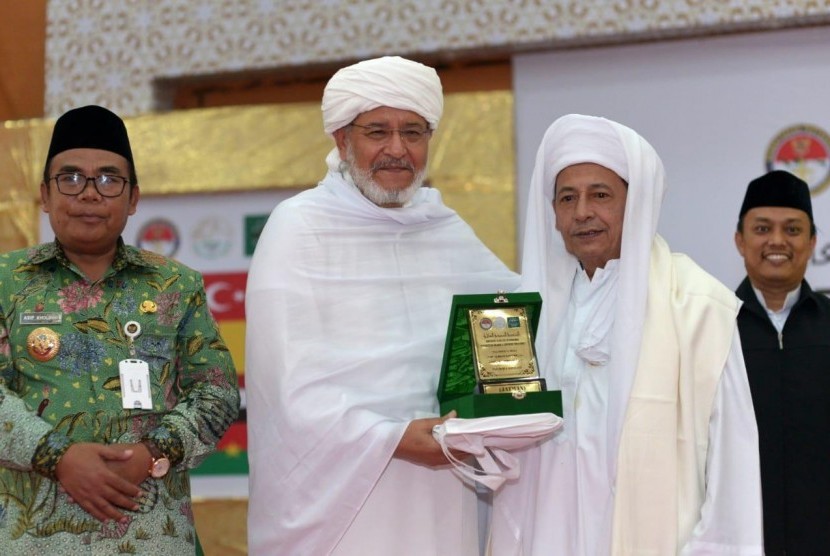 Syekh Muhammad As-Syuhumi Al-Idrisi asal Libya (kedua kiri) menerima cenderamata berupa plakat dari Habib Luthfi bin Ali bin Yahya (kanan) pada agenda penutupan Konferensi Ulama Sufi Internasional di Pekalongan, Jawa Tengah, 10 Apriol 2019. (Foto: Istimewa) 