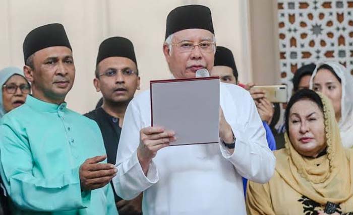 Mantan PM  Malaysia Najib Razak membacakan sumpah laknat usai sholat Jumat di Masjid Kampung Baru, Kuala Lumpur,  Malaysia, didampingi istrinya Rosmah Mansor di kanan. (Foto: MalayMail)