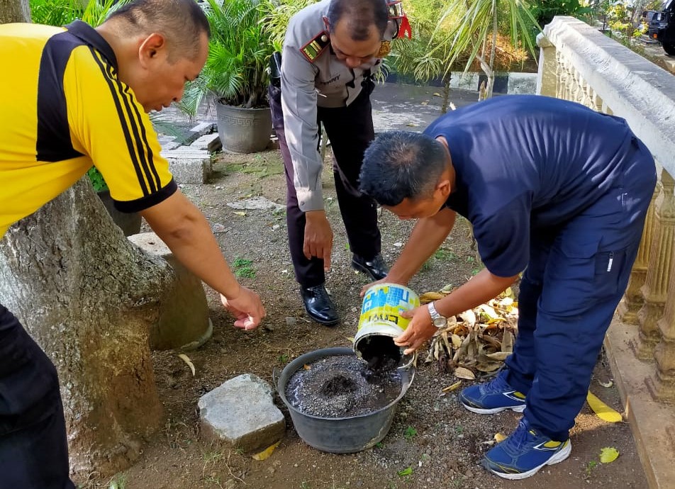 Petugas Polsek Genteng, Polresta Banyuwangi menyimpan benda mirip granat dalam ember plastik beisi air dan pasir (foto : istimewa)