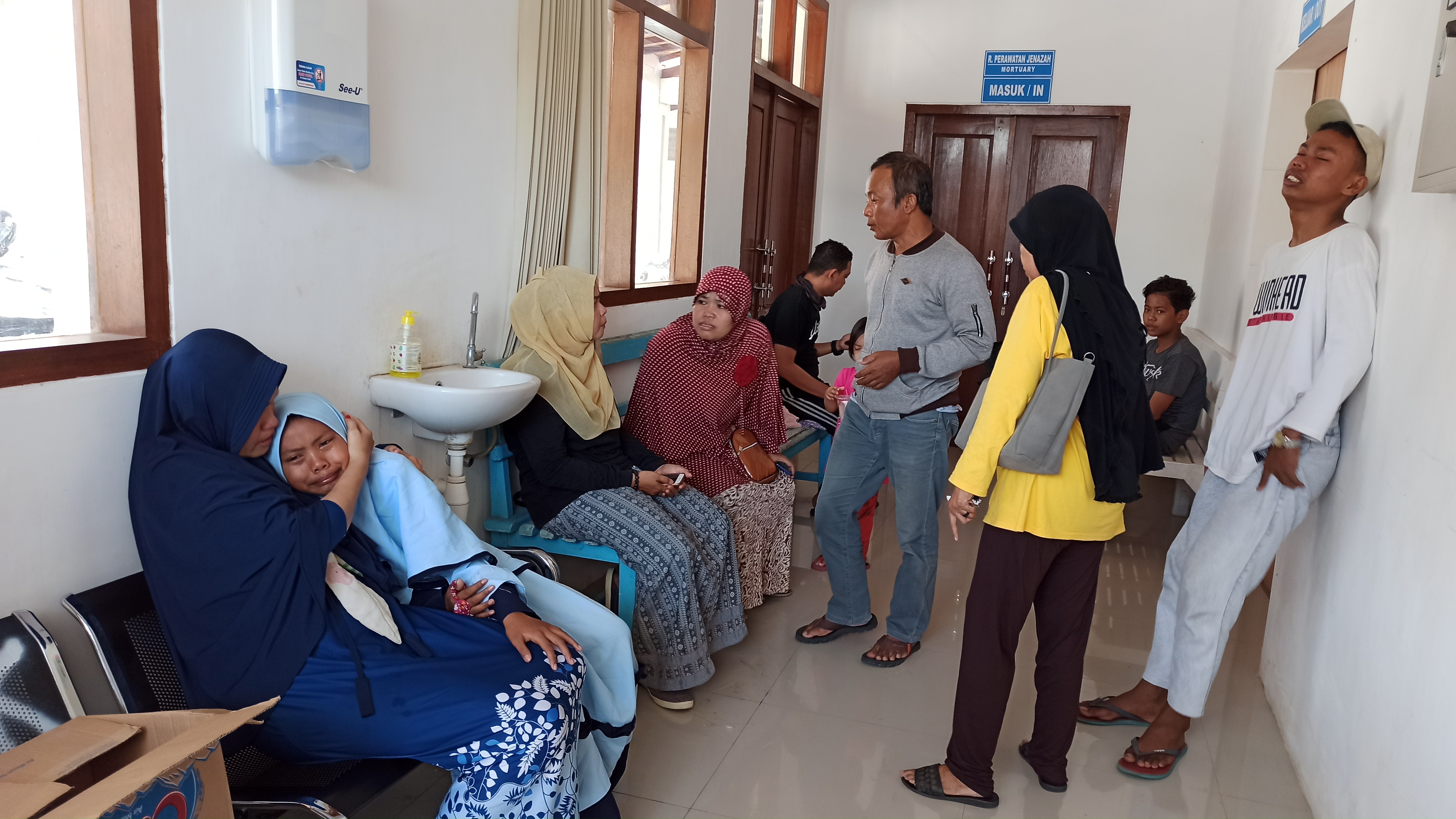 Anak pertama dan kedua korban menangis histeris di kamar mayat RSUD Blambangan sesaat setelah korban dievakuasi (Foto : Hujaini/ngopibareng.id)