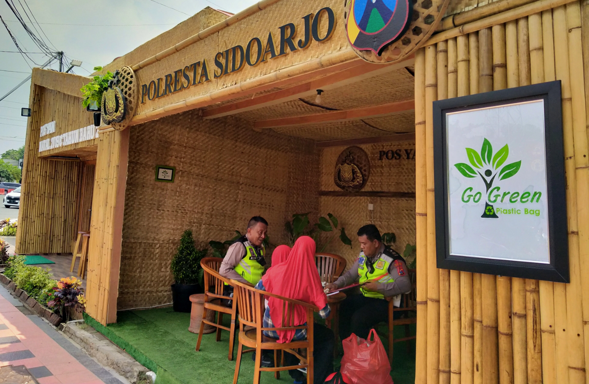 Petugas menerima warga yang ingin menukarkan limbah botol plastik dengan tumbler di Posko Pelayanan Polresta Sidoarjo di Bundaran Taman Pinang, Rabu 25 Desember 2019. (Foto:Fariz/ngopibareng.id)