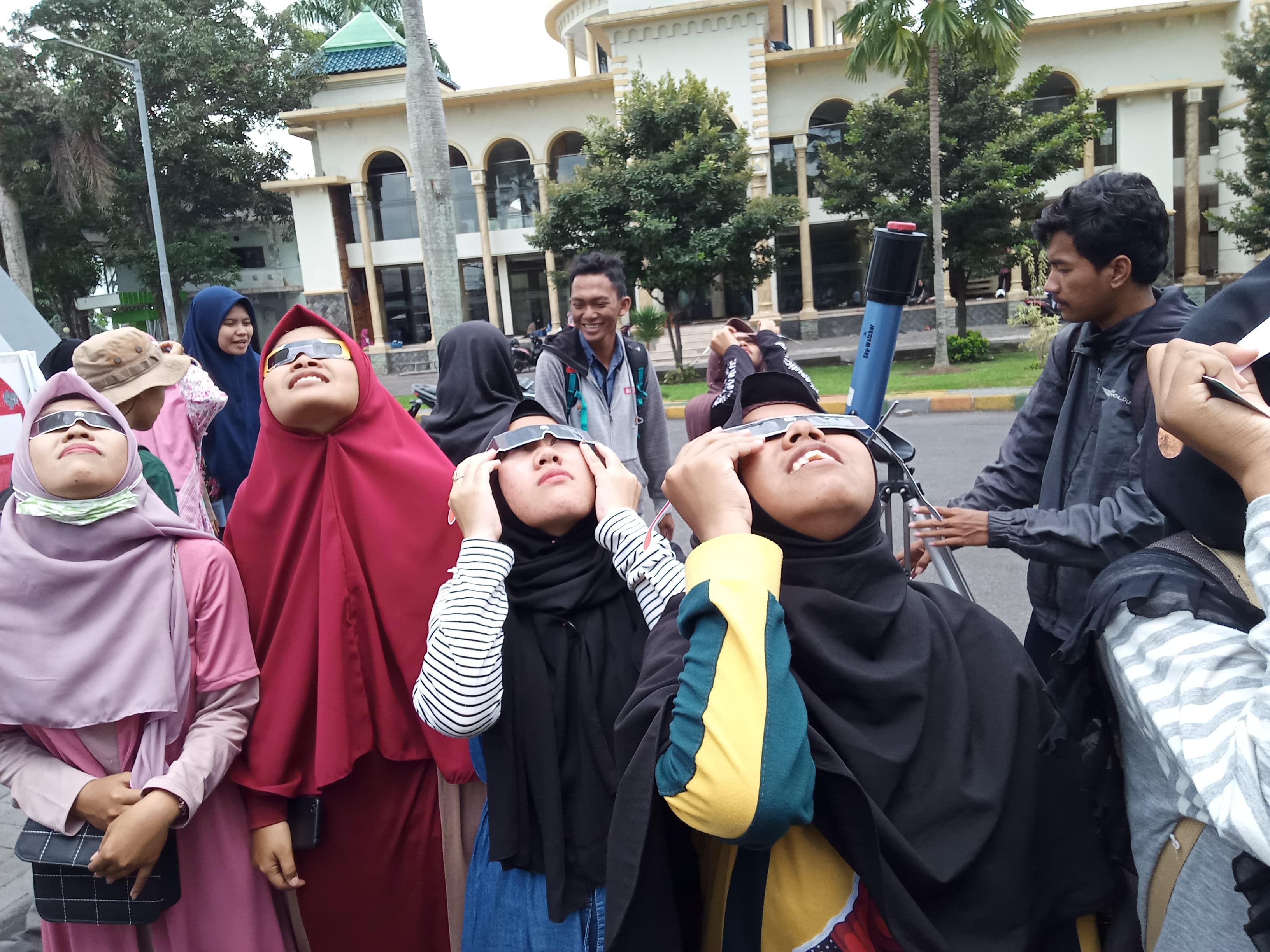 Para mahasiswi UIN Maliki Malang yang mengamati Gerhana Matahari Cincin menggunakan kacamata (Theo/ngopibareng.id)