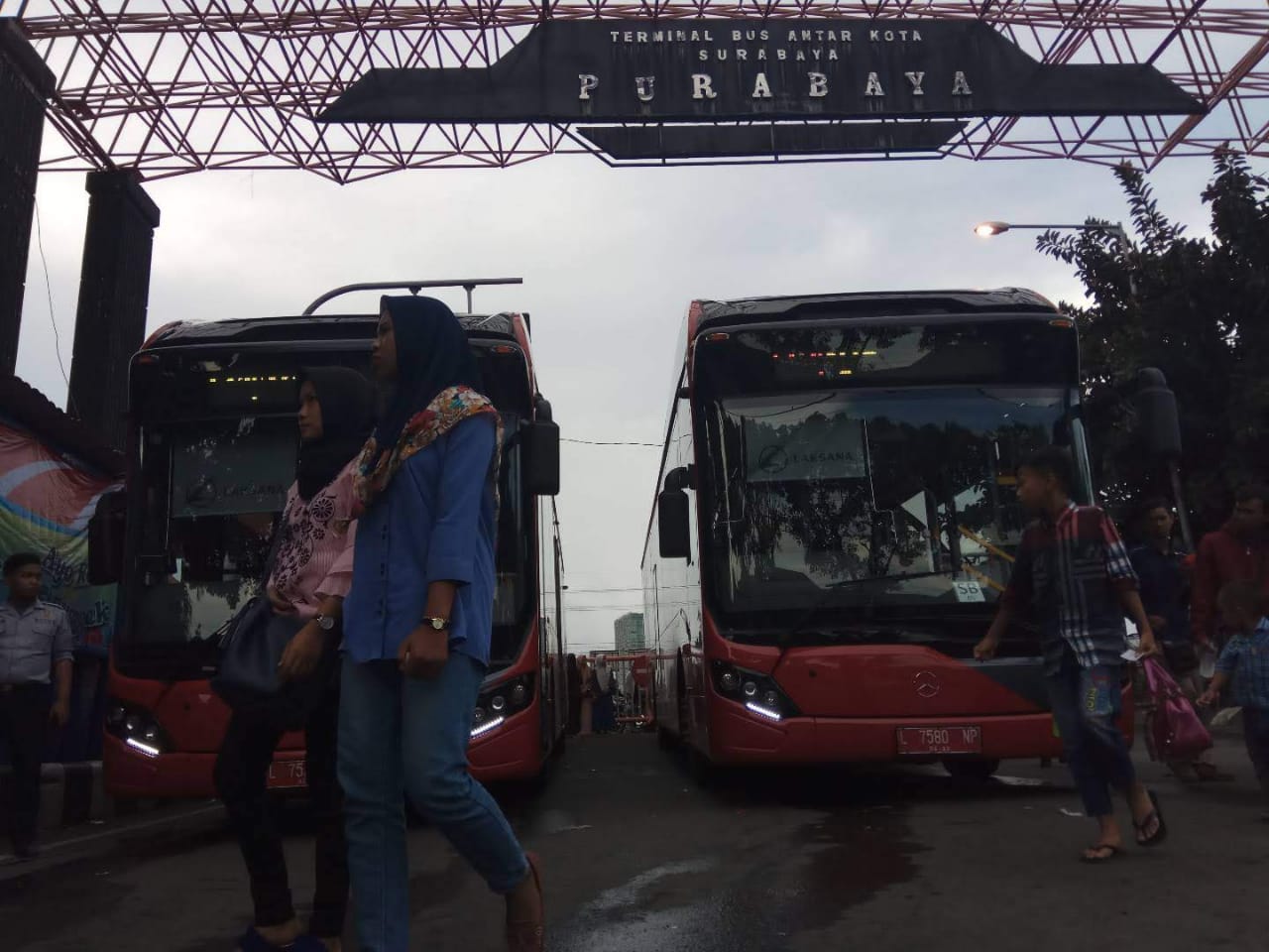 Foto dokumentasi penumpang melintas di depan Suroboyo Bus yang terparkir di Terminal Purbaya. (Foto: Amir/ngopibareng,id)
