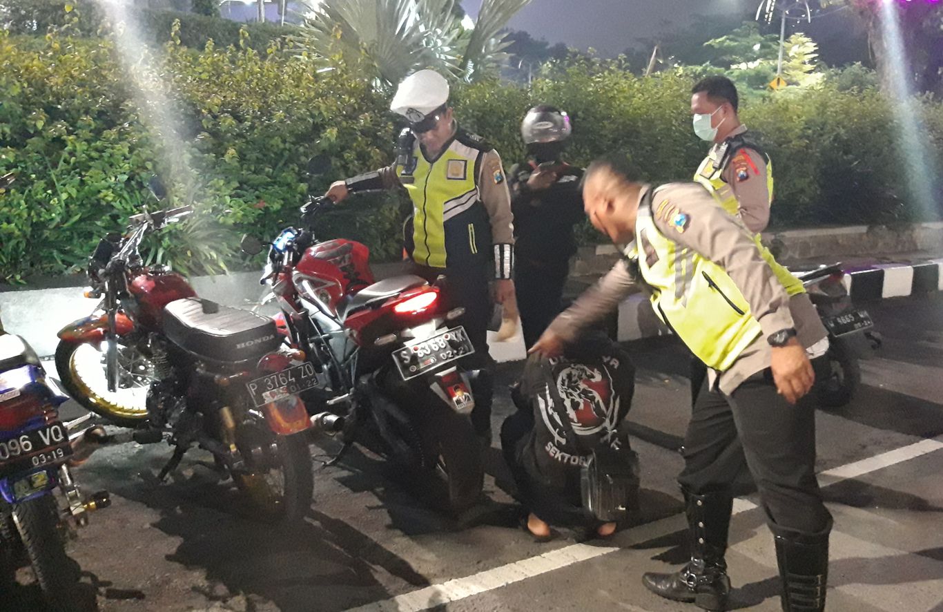 Petugas Satlantas Polrestabes Surabaya menindak pengendara yang menggunakan kenalpot brong di bundaran Waru, Selasa 31 Desember 2019. (Foto: Haris/ngopibareng.id)