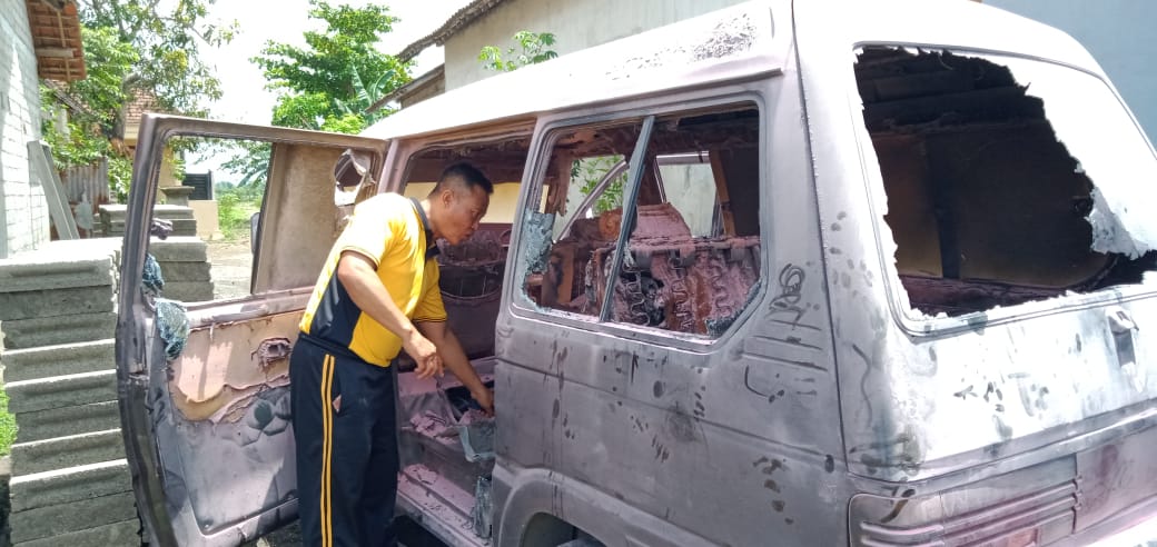 Petugas Polsek Muncar mengecek mobil tipe Suzuki Carry yang terbakar saat mengisi BBM. (Foto : Istimewa)