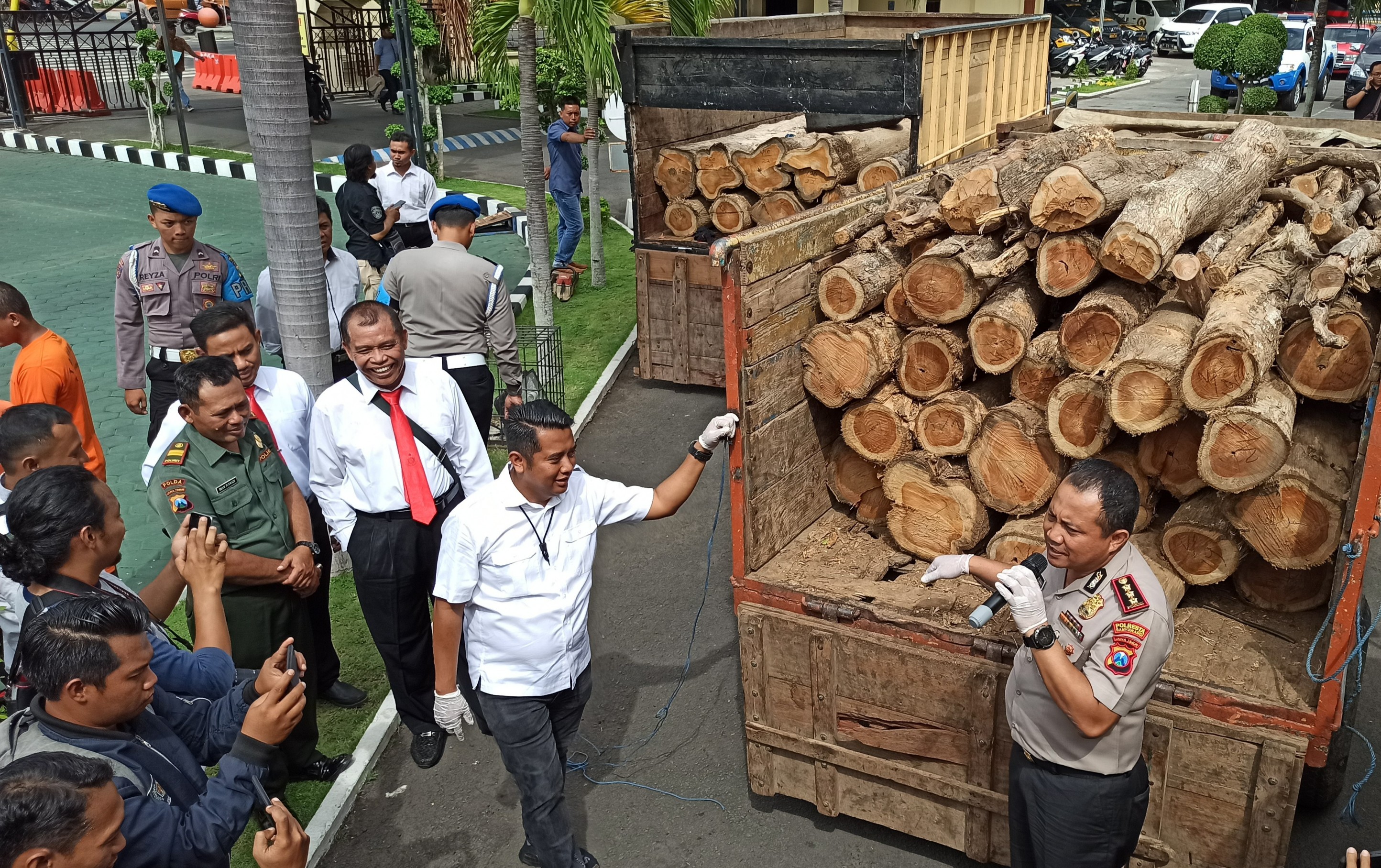 Kapolresta Banyuwangi Kombespol Arman Asmara Syarifudin menunjukkan barang bukti kayu hasil jarahan para pelaku. (Foto: Hujaini/ngopibareng.id)