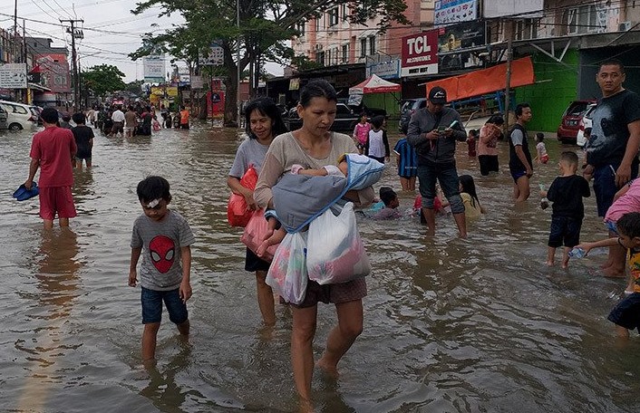 Sejumlah warga masih beraktivitas di genangan air yang merendam jalan Hasyim Ashari Ciledug-Pinang yang merupakan akses penghubung Tangerang, Banten, ke DKI Jakarta. (Foto: Ant)