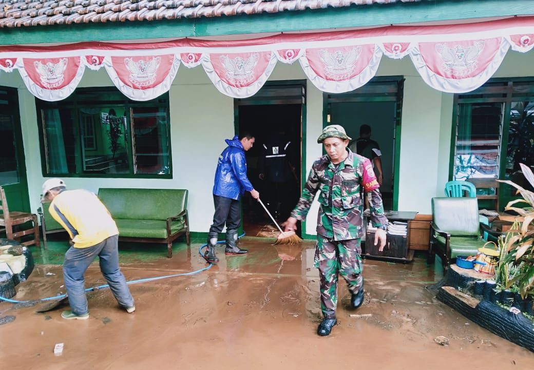 Anggota Koramil sedang membersihkan Kantor Koramil Wongsorejo dari lumpur dan sampah yang terbawa air (foto : Istimewa)