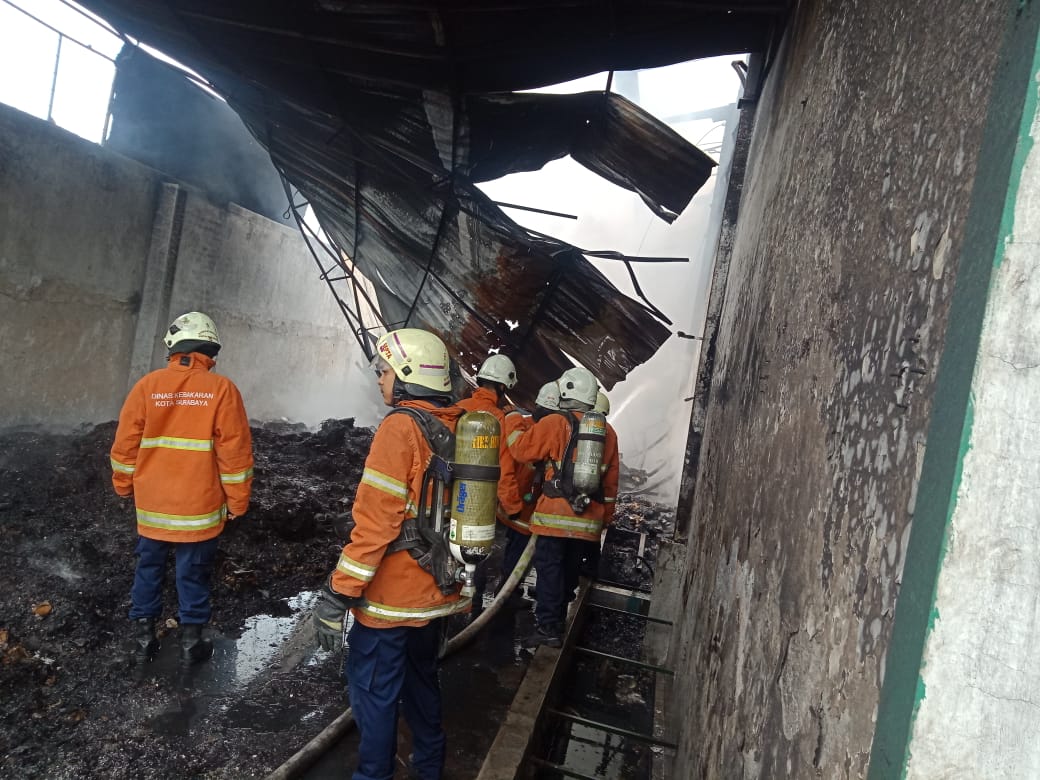 Petugas memadamkan api di bekas gudang penyimpanan spare part motor di Jalan Margomulyo Indah. (Foto: Istimewa)