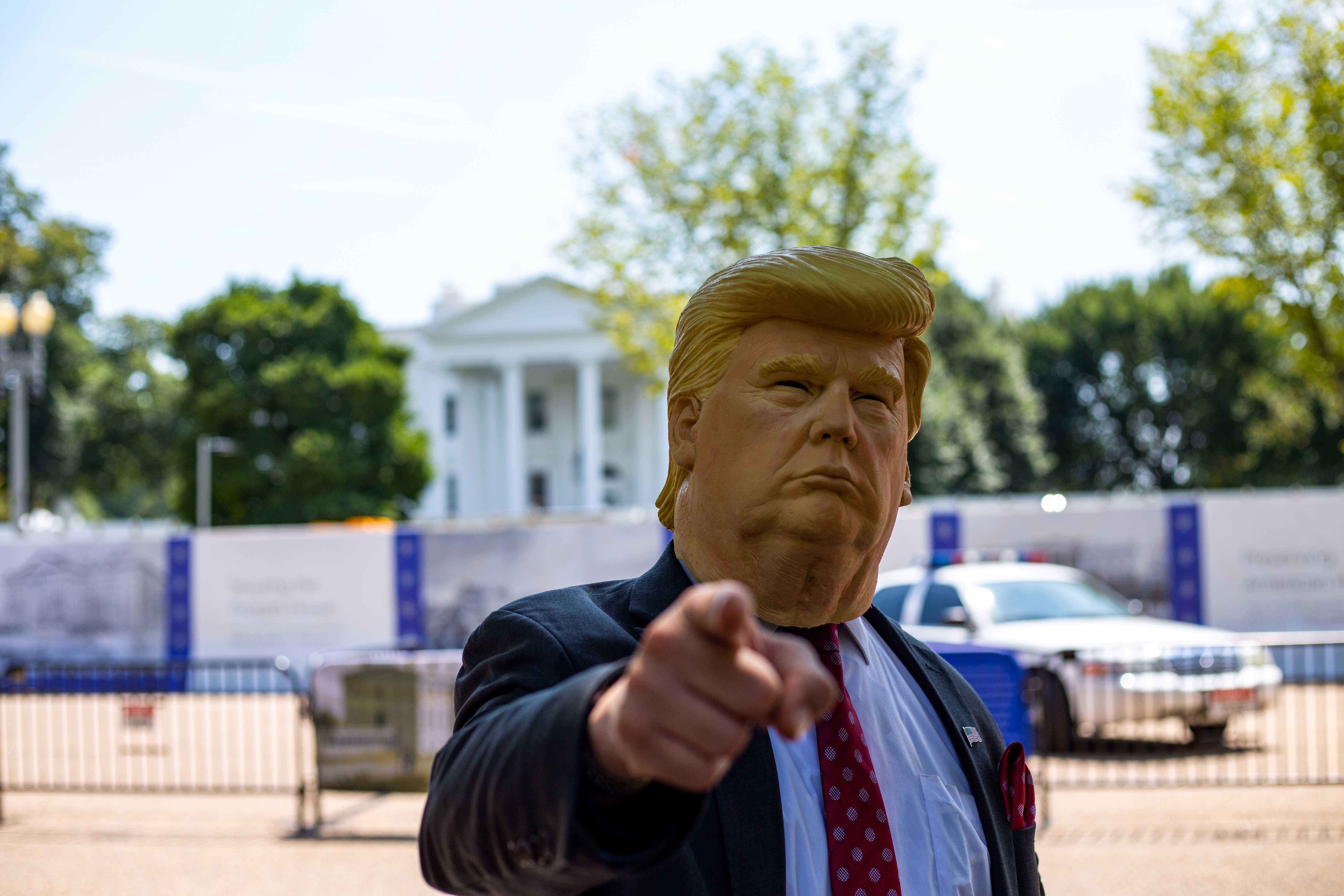 Seorang laki-laki mengenakan topeng menyerupai Presiden Amerika Serikat, Donald Trump. (Foto:Unsplash.com)