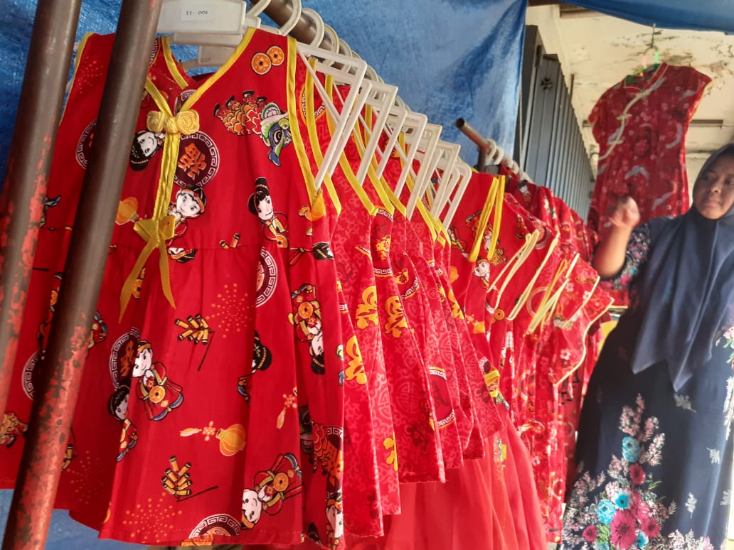 Salah satu penjual baju Cheongsam, Erni Sugiani saat menjajakan barang dagangannya di Jalan Martadinata, di depan Kawasan Klenteng Eng An Kiong, Kota Malang (Theo/ngopibareng.id)