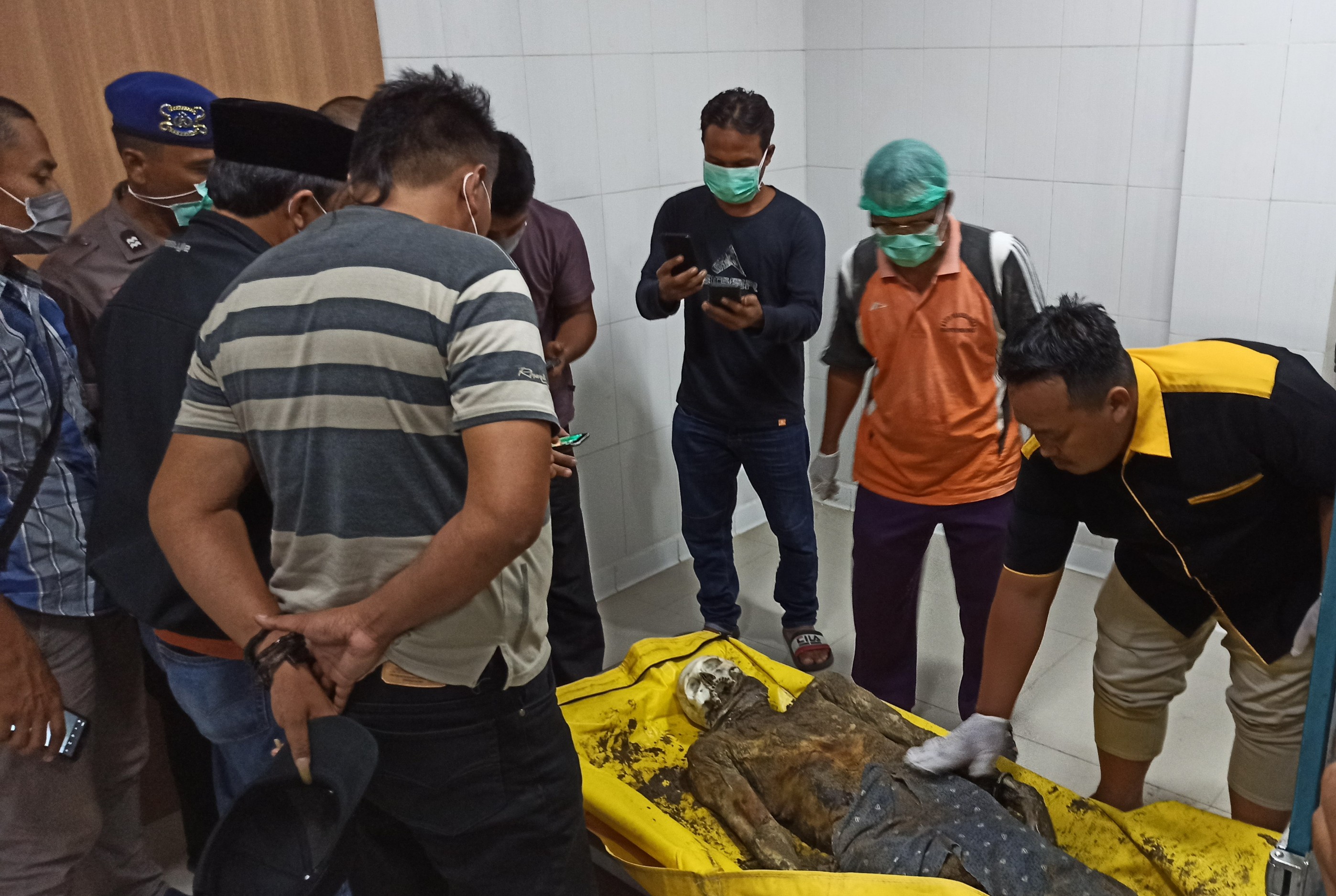 Keluarga korban mengidentifikasi jenazah yang ditemukan di Pantai Taman Nasional Alas Purwo yang disemayamkan di kamar mayat RSUD Blambangan dinihari tadi. (Foto: Hujaini/ngopibareng.id)