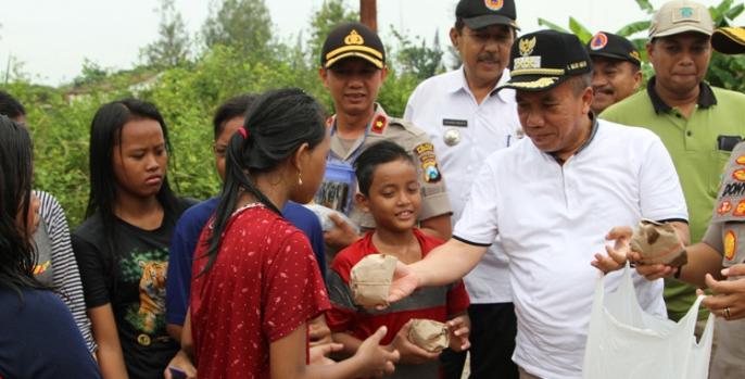 Wakil Bupati Pasuruan KH Mujib Imron membagikan nasi bungkus kepada korban banjir. (Foto: Dok Humas)