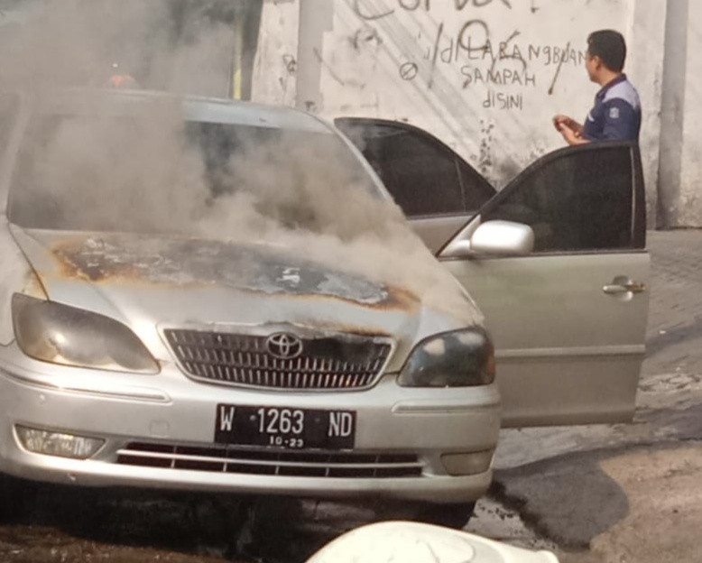 Mobil sedan Toyota Camri yang terbakar di Jalan Putat Jaya. (Faiq/ngopibareng.id)