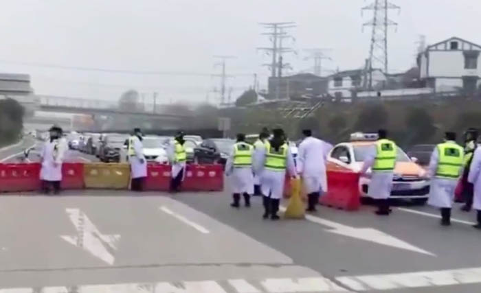Petugas kepolisian dan kesehatan menutup Jalan bebas hambatan yang keluar dan masuk ke Kota Wuhan di Provinsi Hubei. (Foto:DailyExpress)