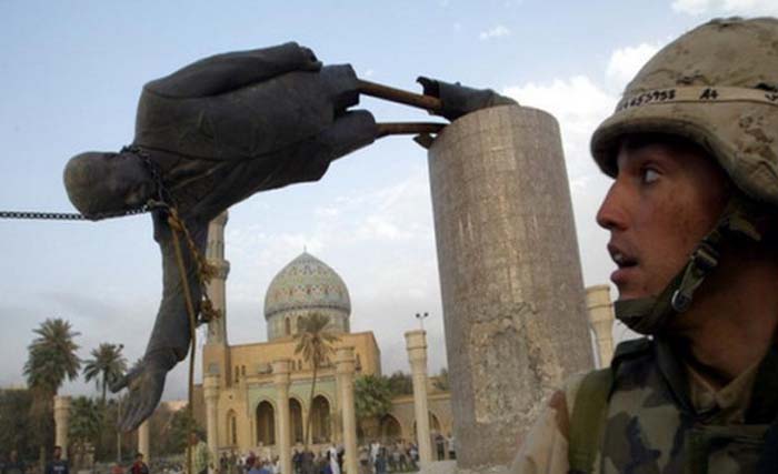Seorang tentara meyaksikan patung Saddam Husein di Baghdad dirobohkan tahun 2003. (Foto:AFP)