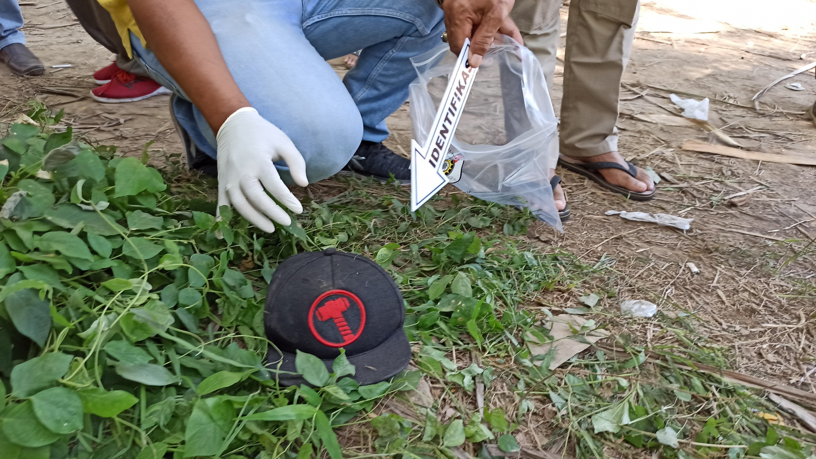 Topi berwarna hitam dengan bordir motif palu ini ditemukan Polisi di sekitar TKP penemuan mayat terbakar (foto : Hujaini/ngopibareng.id)