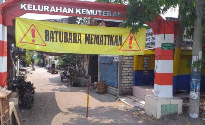 Ilustrasi banner menolak batubara di gapura Kampung Blandongan Kelurahan Kemutran, Kecamatan Gresik Kota. (Foto:Dok.Ngopibareng)