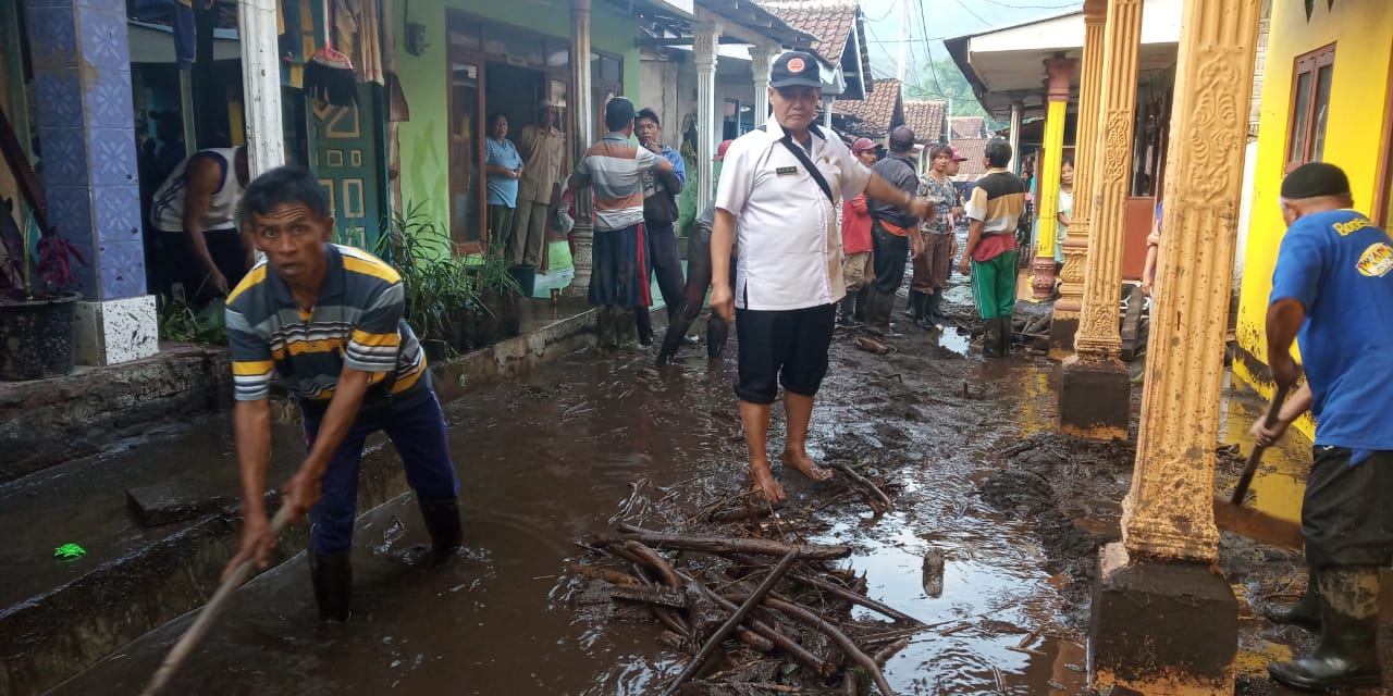Warga dan dinas terkait sedang membersihkan sisa lumpur akibat banjir bandang. (Foto:istimewa)
