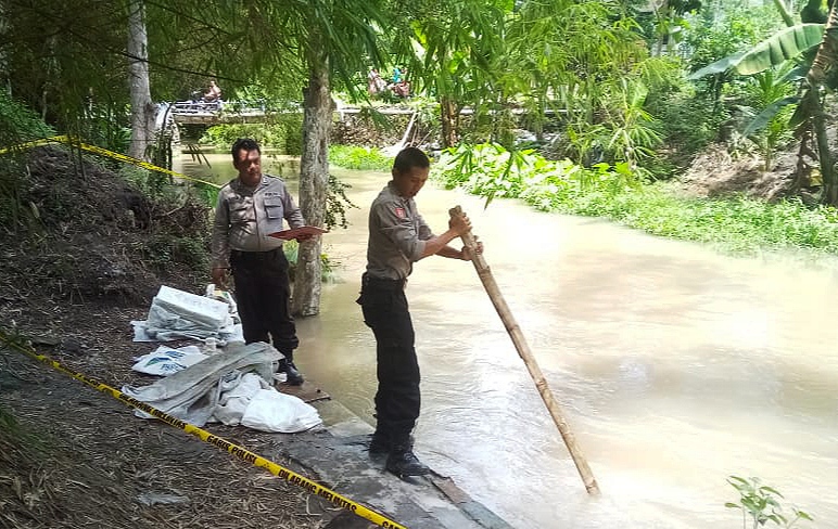 Petugas Polsek Tegaldlimo melakukan olah TKP di sungai tempat korban Rubinem ditemukan (Foto: istimewa)