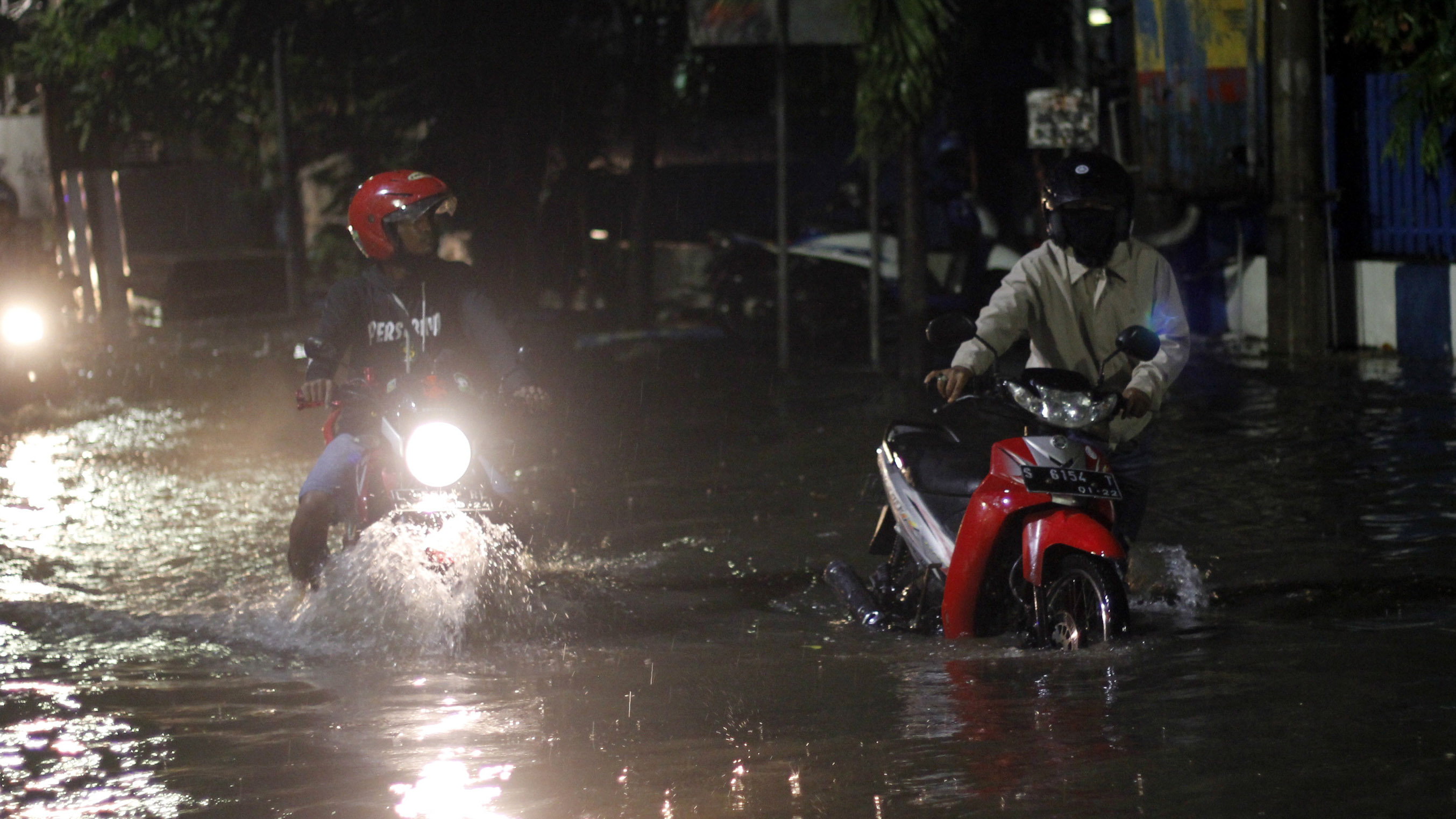 Pengendara sepeda motor yang menerobos banjir di Jalan Bogowonto, Surabaya, Jumat 31 Januari 2020. (Foto: Fariz/ngopibareng.id)