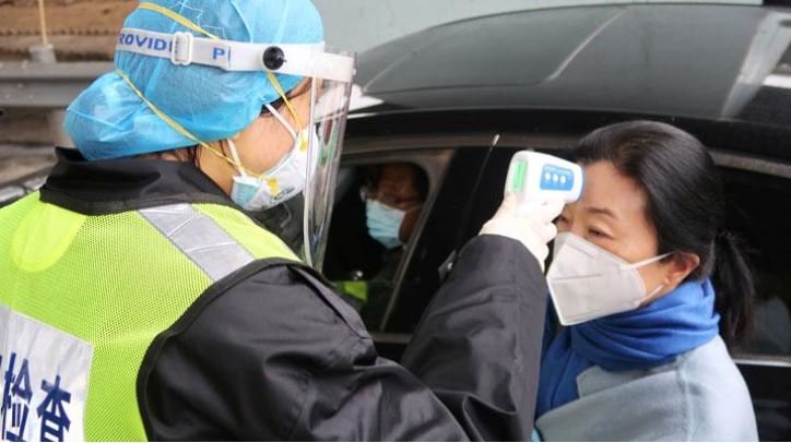 Petugas memeriksa suhu tubuh penduduk di Provinsi Hubei, China. Pemkab Natuna liburkan sejumlah sekolah lantaran khawatir tertular virus corona. (Foto:reuters) 