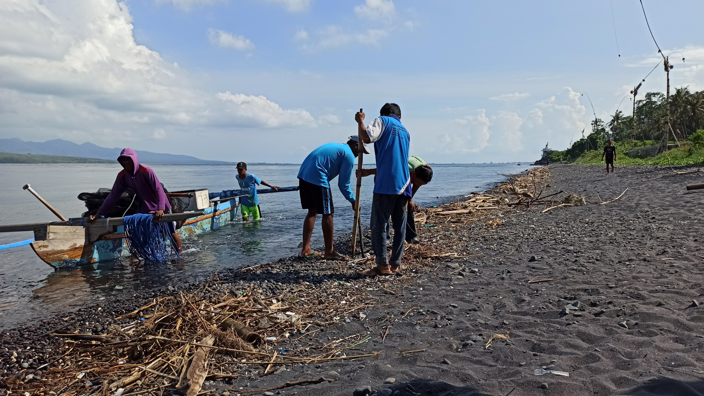 Anggota Pokmaswas bersama nelayan membersihkan sampah kiriman yang ada di sekitar pantai Grand Watu Dodol. (Foto: Hujaini/ngopibareng.id)