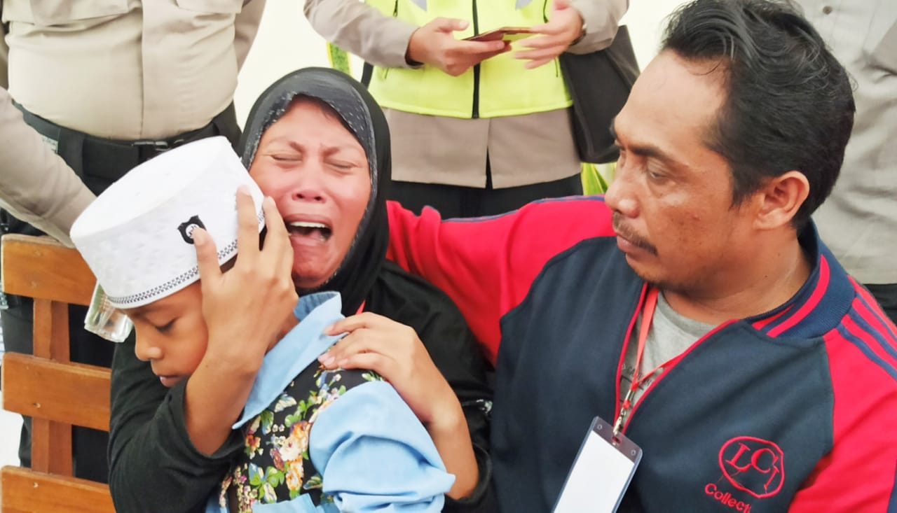 Rita Sahara menangis histeris sambil memeluk anaknya yang kecil (foto : Hujaini/ngopibareng.id)