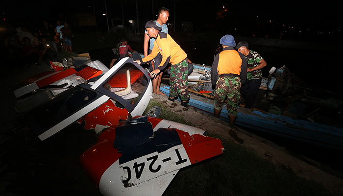 Personel dari TNI Angkatan Laut menurunkan bagian puing pesawat dari kapal nelayan. (Foto: Erfan Hazransyah/ngopibareng.id)