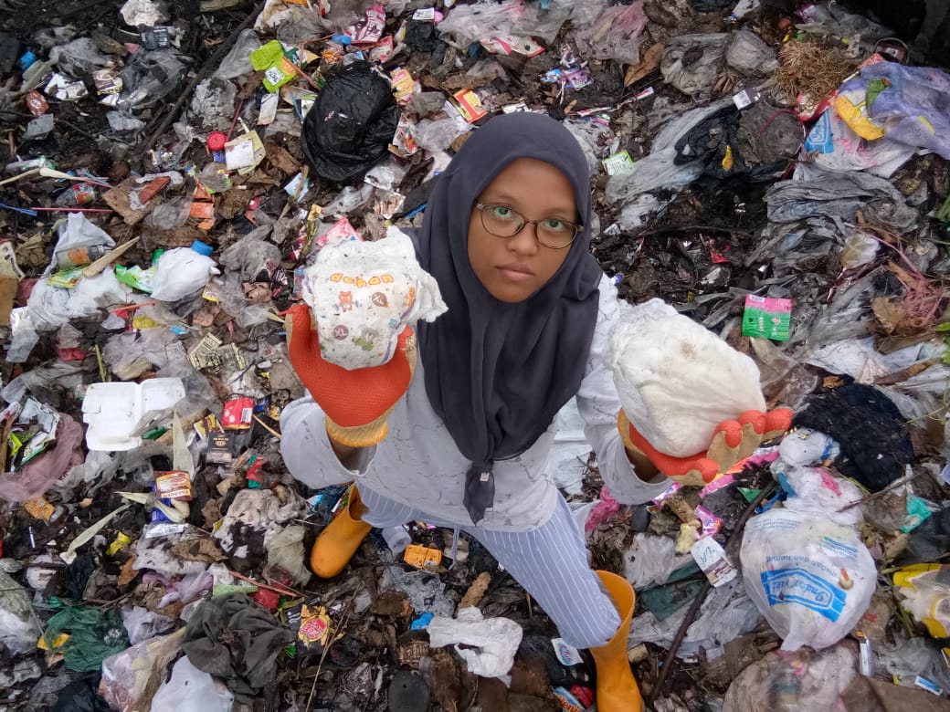 Thara Bening menunjukkan sampah popok saat bersama gerakan pembersih sampah Rewind, di Gresik. (Foto:ecoton/ngopibareng.id)