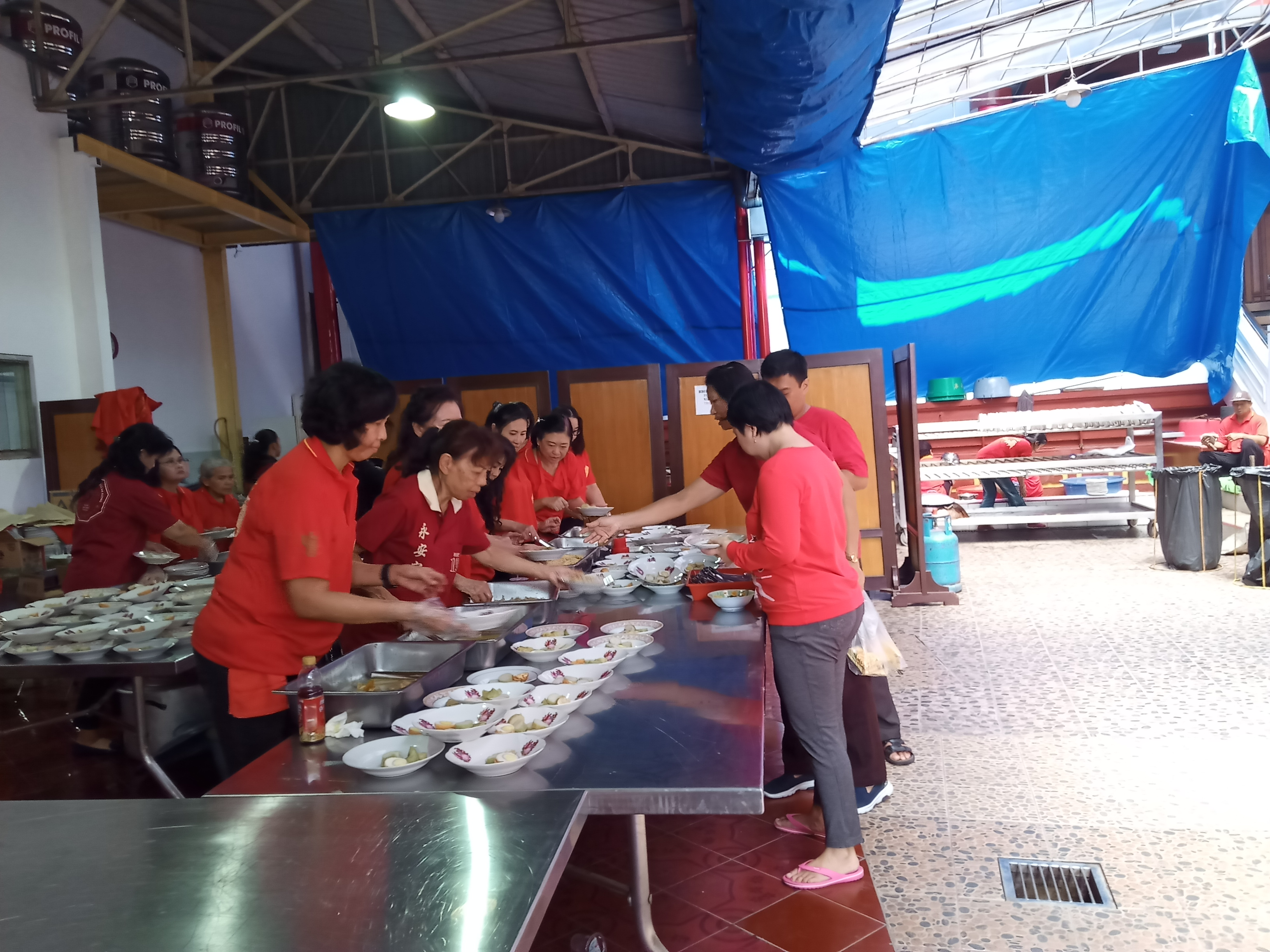 Para pelayan saat membagikan lontong kepada masyarakat di Klenteng Eng An Kiong, Kota Malang (Theo/ngopibareng.id)
