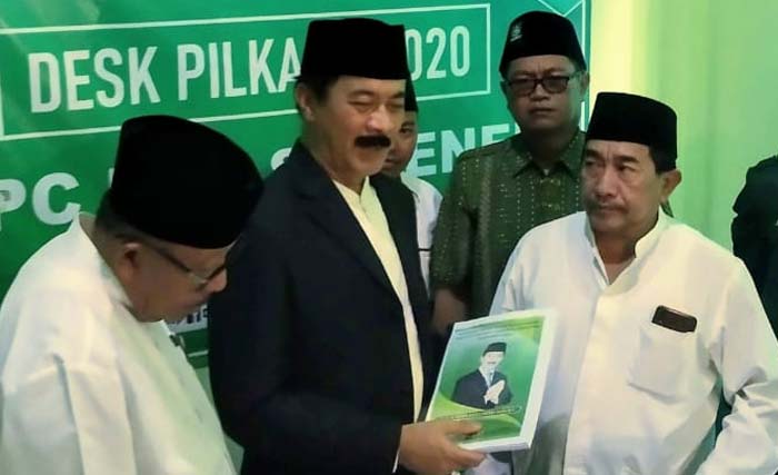 Fattah Jasin (tengah) didampingi Imam Utomo (kiri), mengembalikan formulir pendaftaran di kantor DPC PKB Kabupaten Sumenep. (Foto:yes)