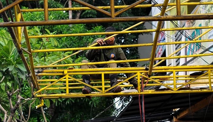 Satpol PP memotong rangka kanopi yang berdiri di atas saluran air di Jalam Ngagel Jaya Selatan, Surabaya, Rabu 12 Februari 2020. (Foto: Erfan Hazransyah/ngopibareng.id)