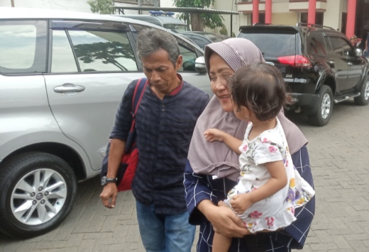Zikria bersama dengan anak dan suaminya, di halaman kantor Polrestabes Surabaya (Andhi Dwi Setiawan/Ngopibareng) 