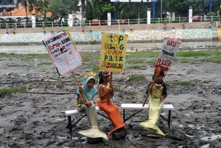 Tiga putri duyung melakukan aksi di Kali Mas, Surabaya, Senin 17 Februari 2020. (Foto: Pitasari/Ngopibareng.id)