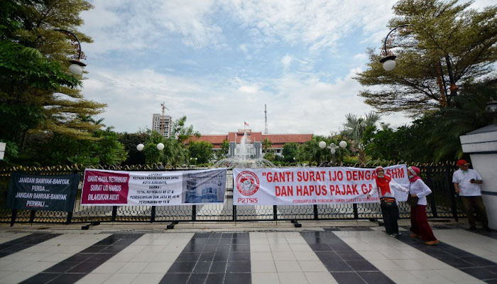 Puluhan spanduk dibentangkan tepat di depan Balai Kota Surabaya oleh pemilik Surat Ijo Surabaya, Senin 17 Februari 2020. (Foto: Erfan Hazransyah/Ngopibareng.id)