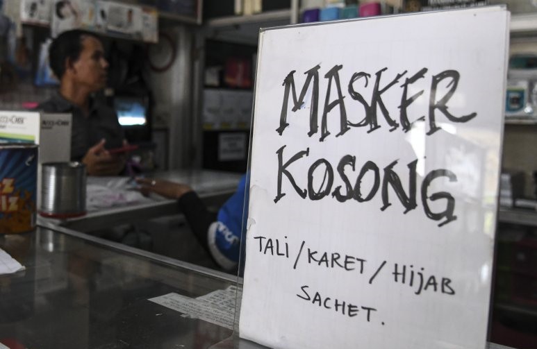 Salah satu toko memasang pengumuman stok masker kosong. (Foto: Antara)