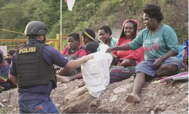  Petugas kepolisian membagikan makanan kepada warga yang mengungsi karena diteror kelompok kriminal bersenjata (KKB), di Timika, Papua, Jumat 6 Maret 2020 (Foto: Antara/Satgas Humas Ops Nemangkawi)