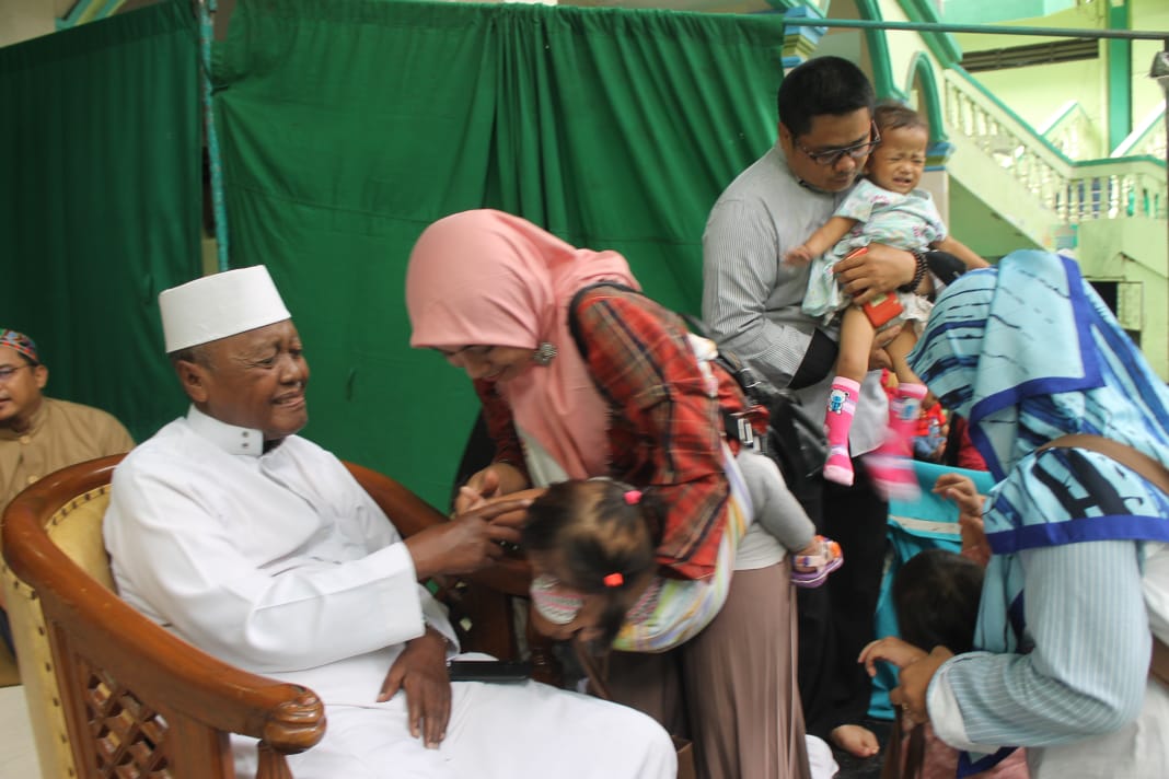 Para alumni santri Pondok Pesantren Assiddiqiyah Jakarta berebut foto bersama dengan KH Nur Muhammad Iskandar sebagai 'tombo kangen' (Foto: Asmanu/Ngopibareng.id)